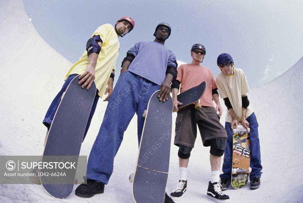 Stock Photo: 1042-6624A Low angle view of a group of young men holding skateboards