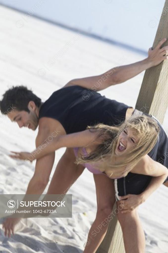 Stock Photo: 1042-6733A Young couple playing on the beach