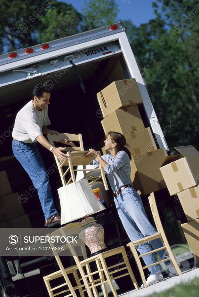Stock Photo: 1042-682A Mid adult couple unloading cardboard boxes from a moving van