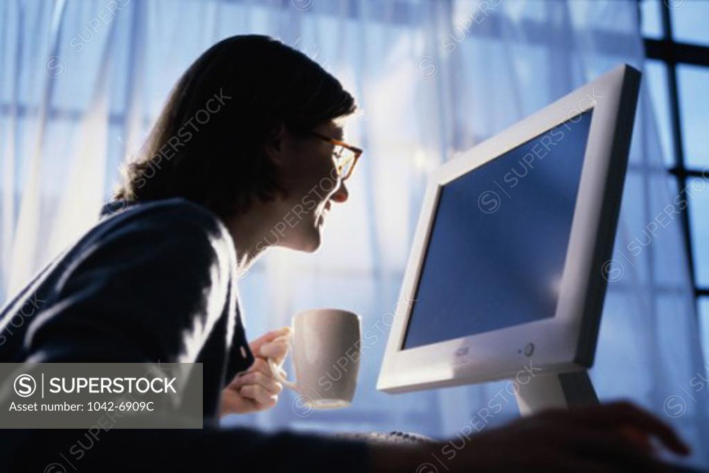 Stock Photo: 1042-6909C Side profile of a young woman using a computer