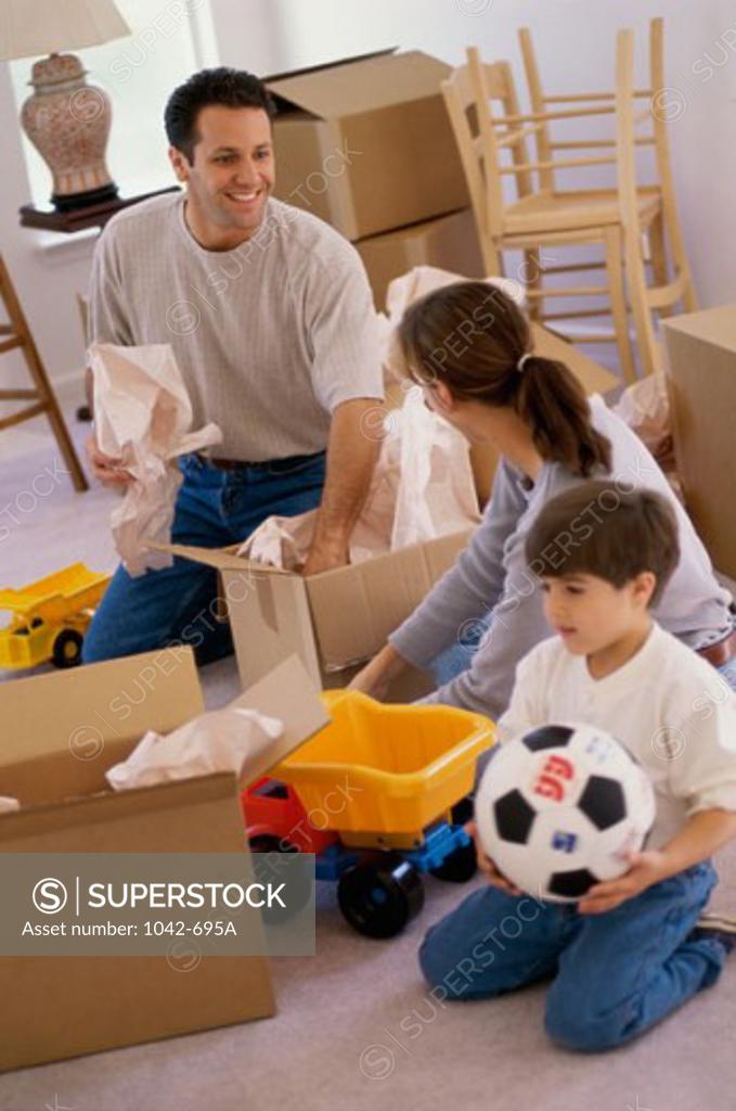 Stock Photo: 1042-695A Parents and their son unpacking boxes