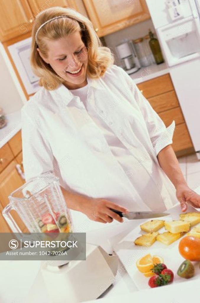 Stock Photo: 1042-7026A Pregnant woman cutting fruit