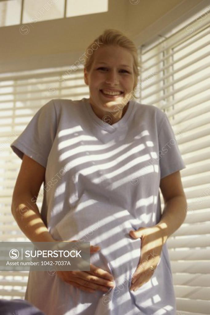 Stock Photo: 1042-7037A Portrait of a pregnant young woman holding her abdomen