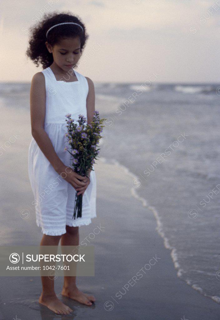 Stock Photo: 1042-7601 Girl holding a bouquet of flowers on the beach