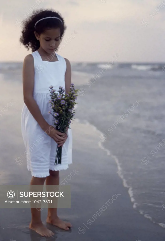 Girl holding a bouquet of flowers on the beach