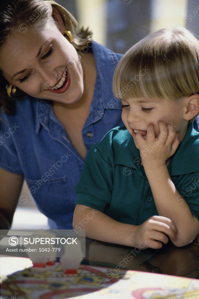 Stock Photo: 1042-779 Mid adult woman playing a board game with her son