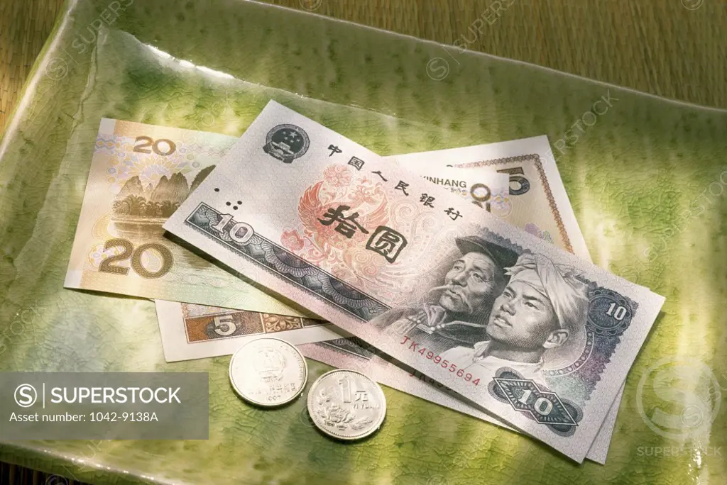 Close-up of yuan notes with coins