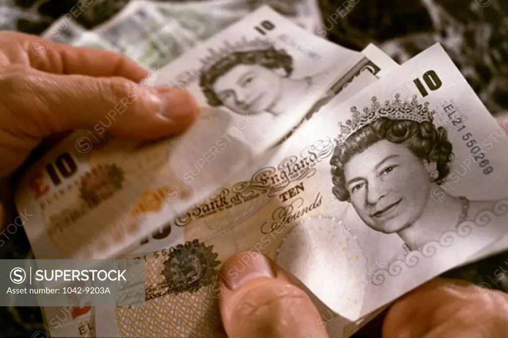 Close-up of ten pound notes in a person's hands