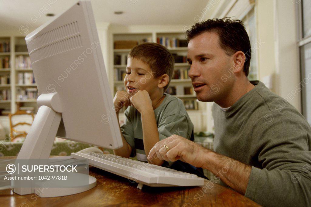 Stock Photo: 1042-9781B Young man and his son using a computer