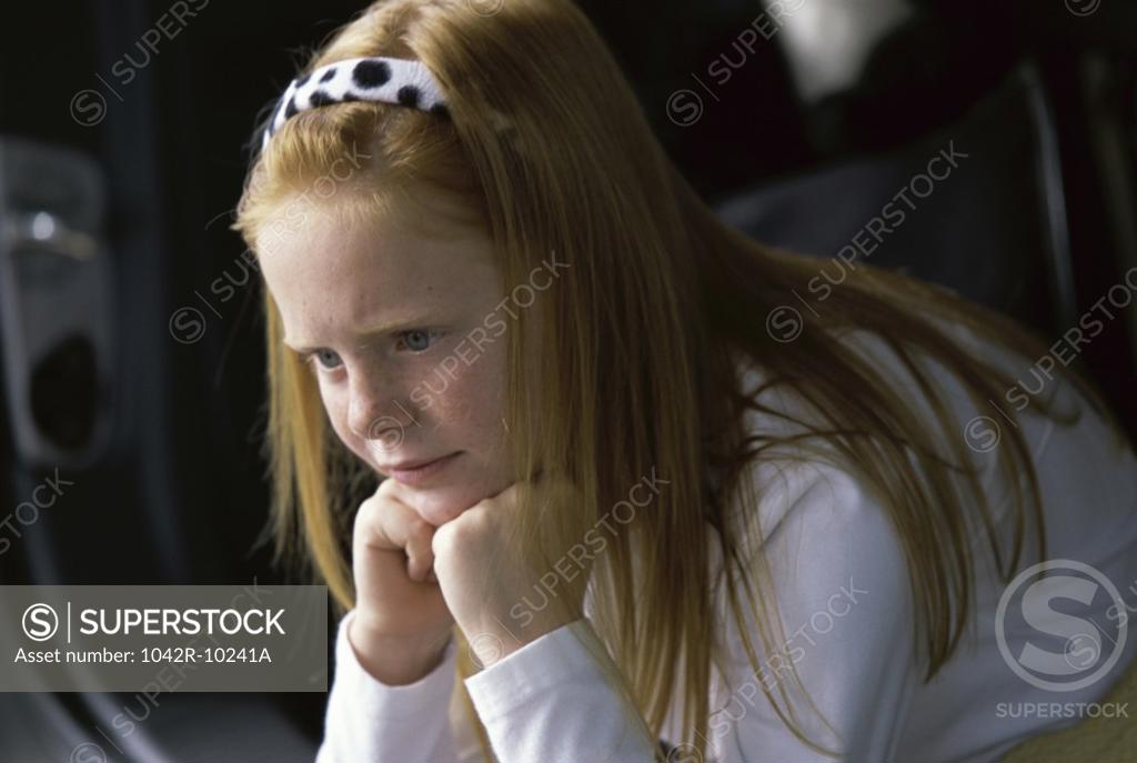 Stock Photo: 1042R-10241A Side profile of a girl sitting with her hands on her chin