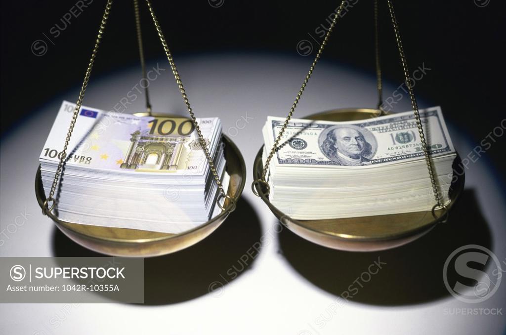 Stock Photo: 1042R-10355A Stack of Euro and American dollar bills on a balance scale