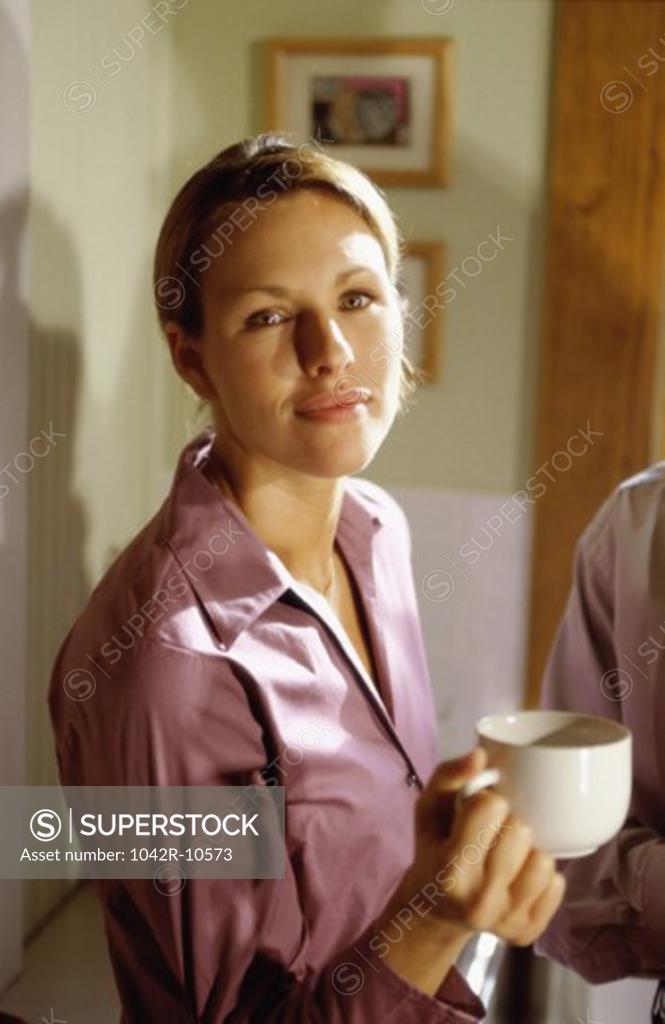 Stock Photo: 1042R-10573 Portrait of a young woman holding a mug