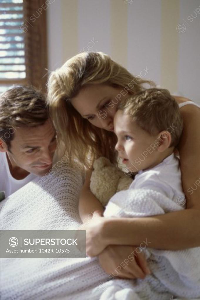 Stock Photo: 1042R-10575 Mother hugging her son on a bed