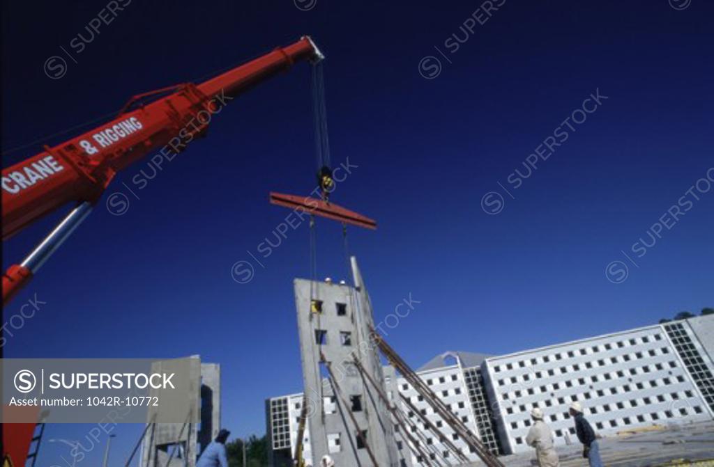 Stock Photo: 1042R-10772 Low angle view of a crane carrying a section of a building