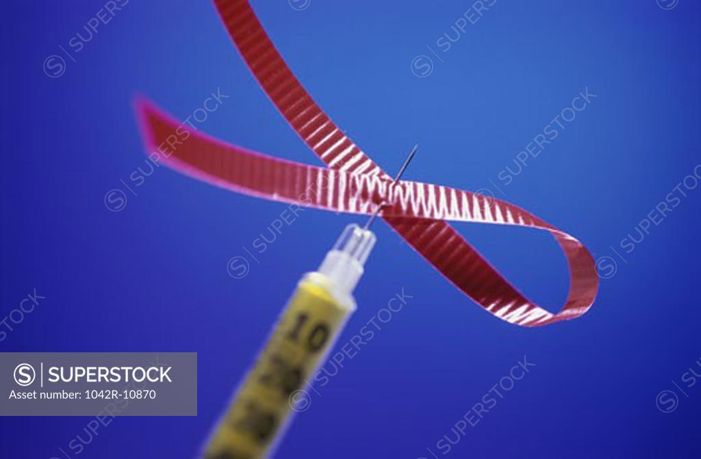 Stock Photo: 1042R-10870 Close-up of a syringe with an AIDS awareness ribbon