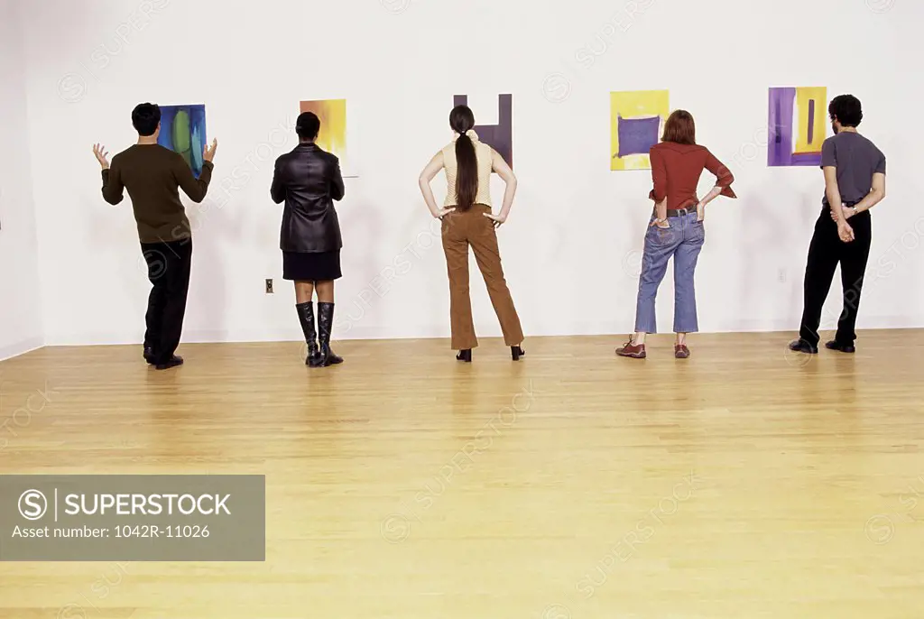 Group of people looking at paintings in an art gallery