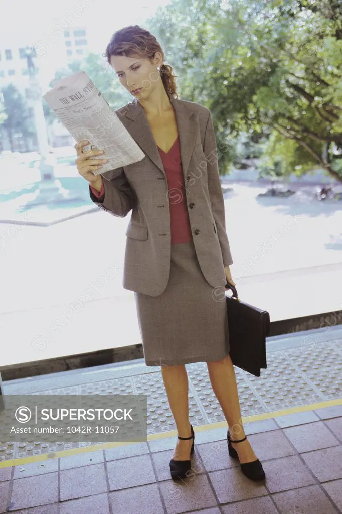 Businesswoman holding a newspaper and a briefcase