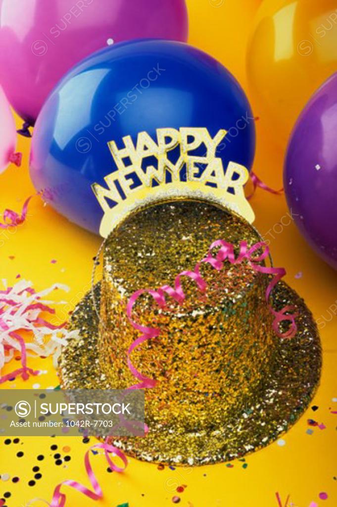 Stock Photo: 1042R-7703 Sequined hat with a Happy New Year sign and streamers with balloons