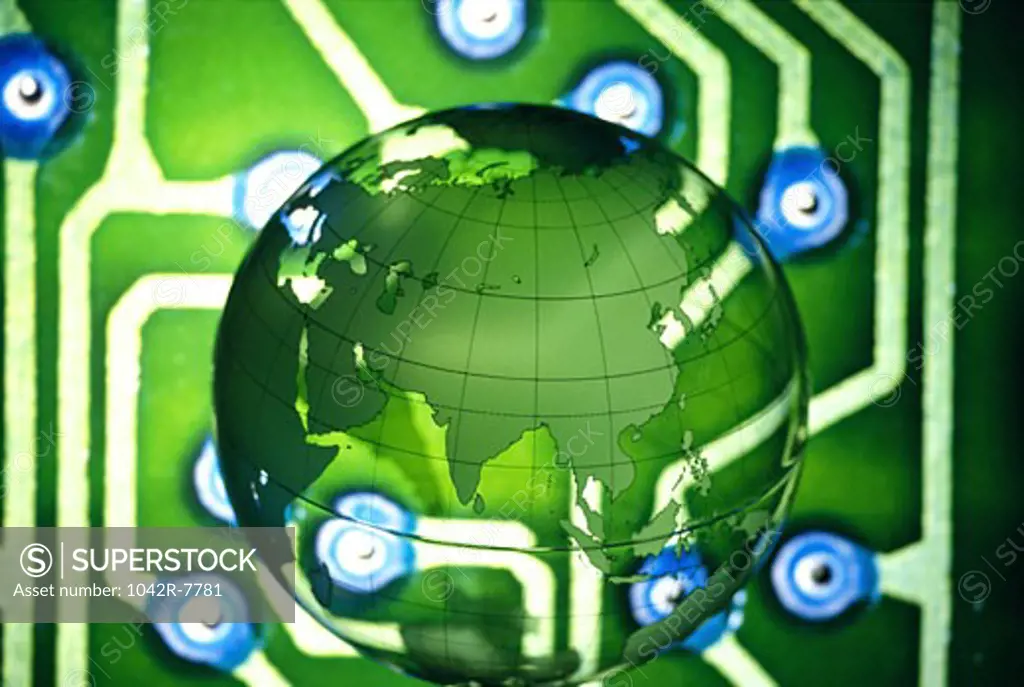 Close-up of a globe superimposed over a circuit board
