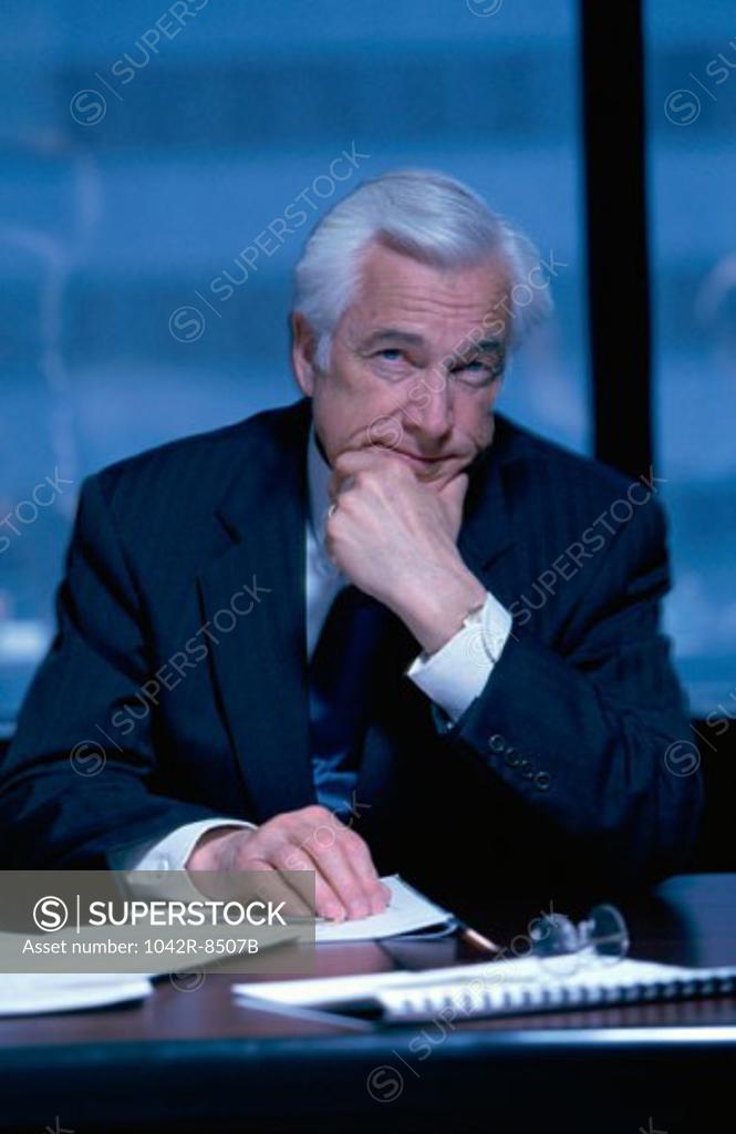 Stock Photo: 1042R-8507B Portrait of senior businessman seated at an office desk