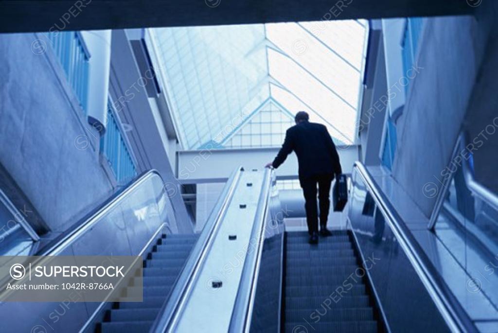 Stock Photo: 1042R-8766A Rear view of a businessman on an escalator