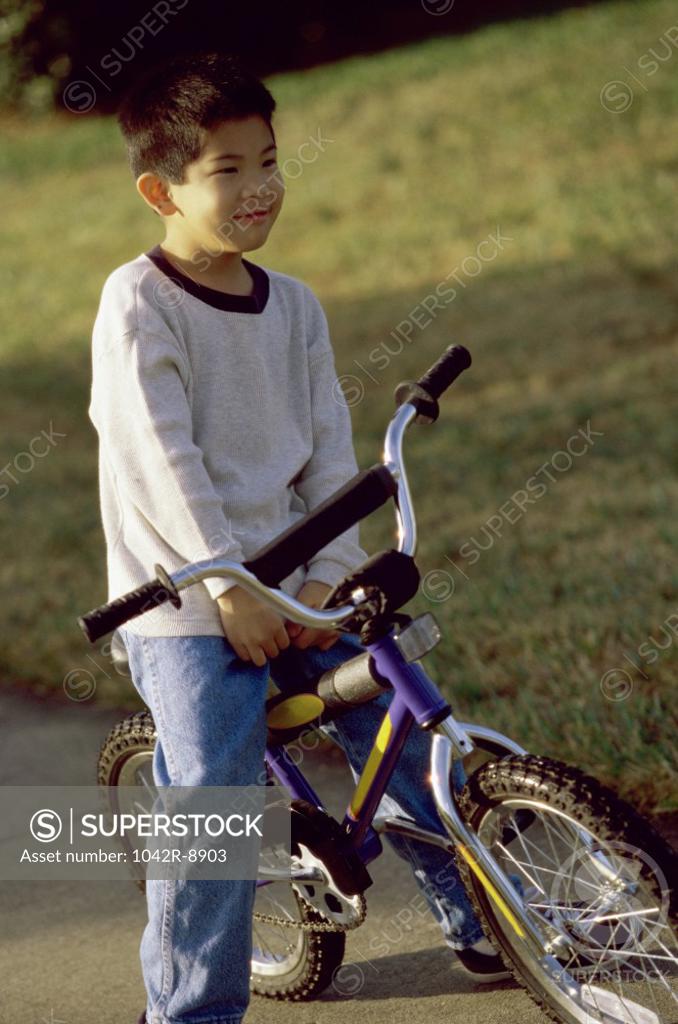 Stock Photo: 1042R-8903 Boy sitting on a bicycle