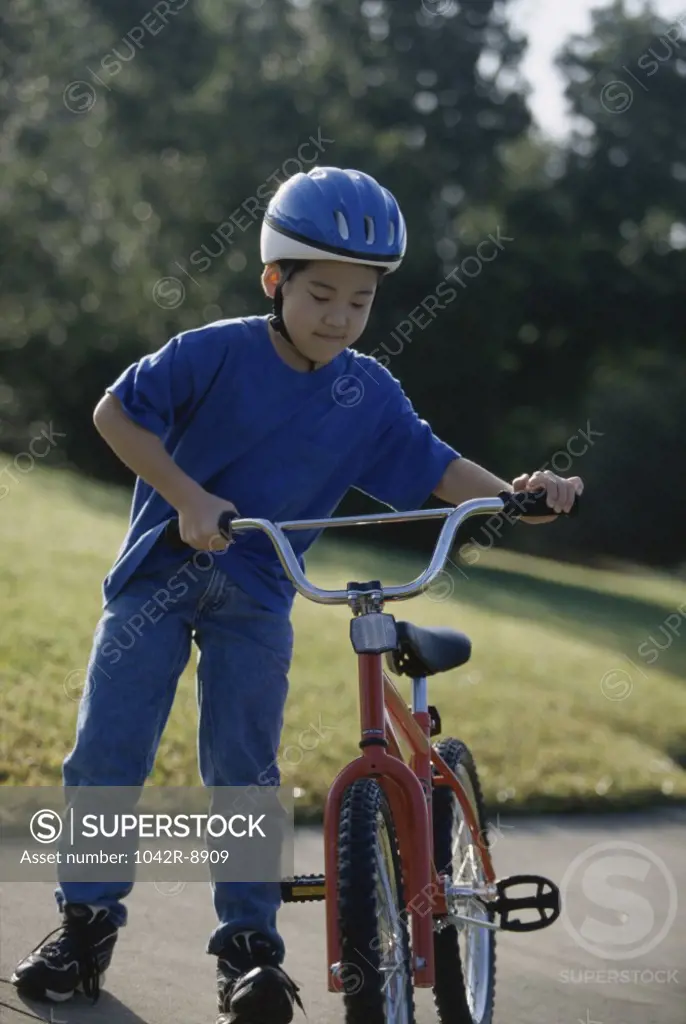 Boy holding a bicycle
