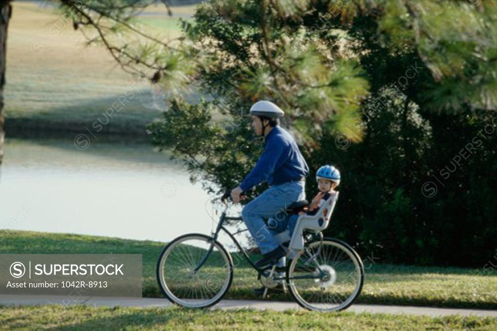 Stock Photo: 1042R-8913 Father and son on a bicycle