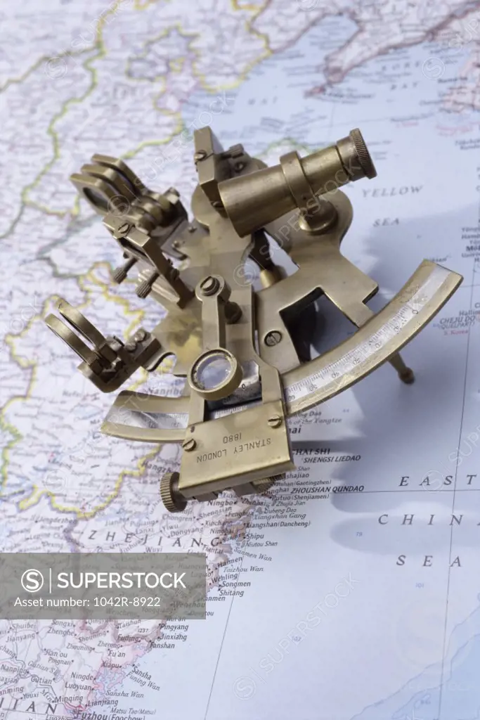 Antique sextant on a map