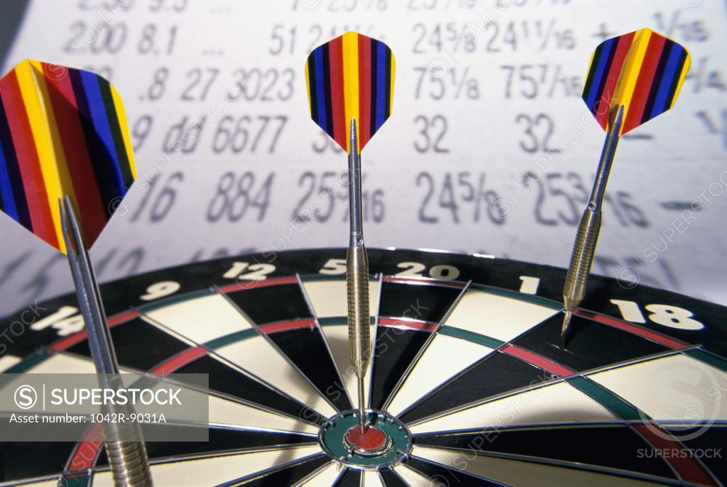 Stock Photo: 1042R-9031A Darts on a dartboard with stock figures in the background