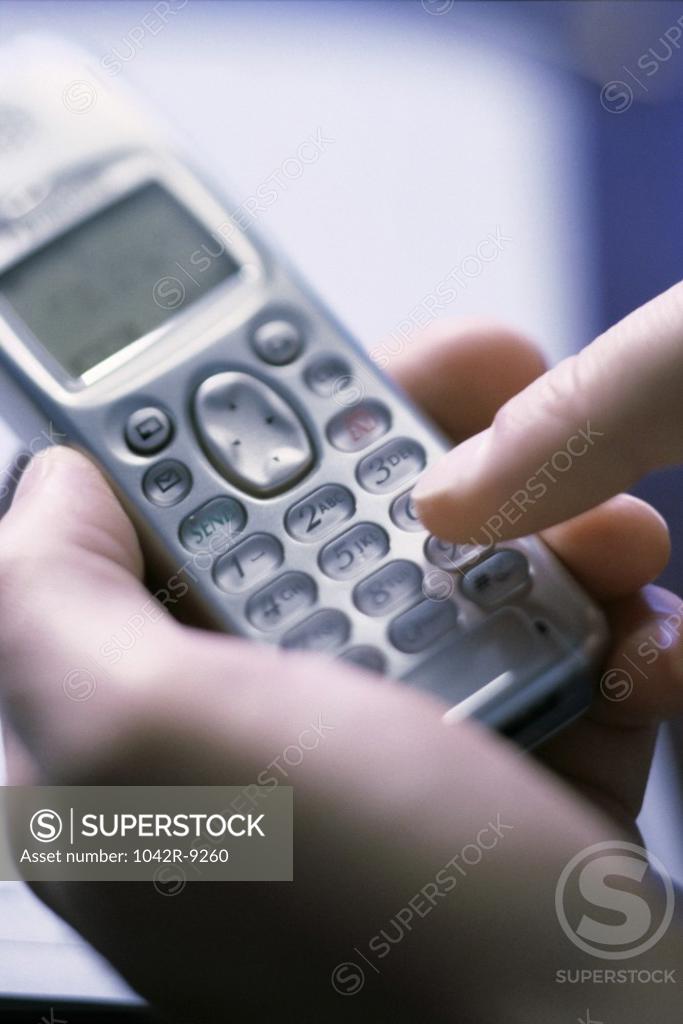 Stock Photo: 1042R-9260 Person operating a mobile phone