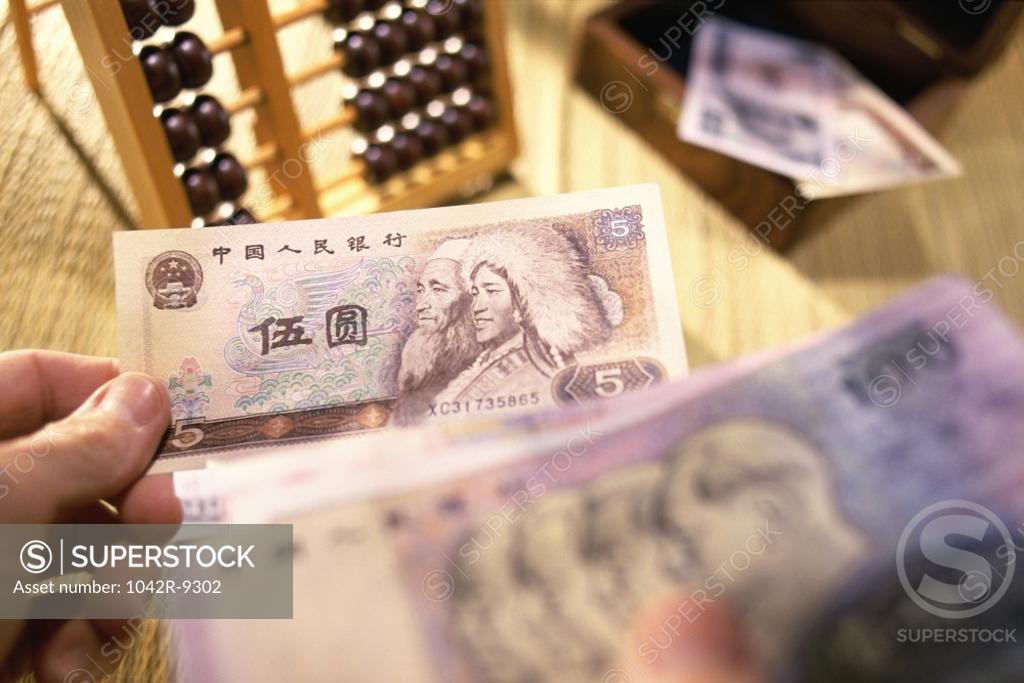 Stock Photo: 1042R-9302 Person's hand holding Yuan banknotes