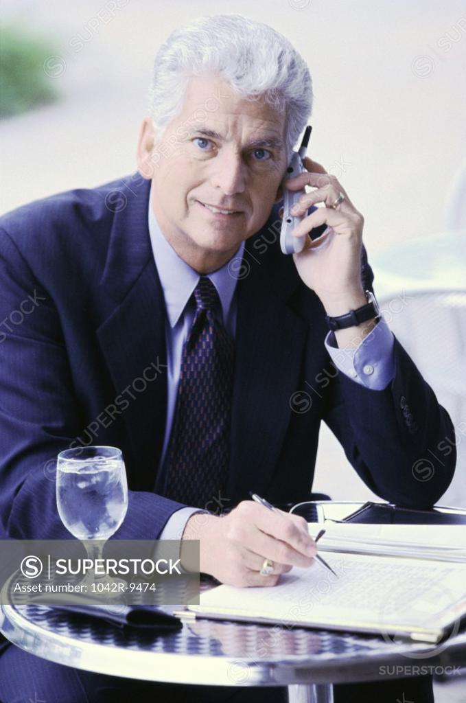 Stock Photo: 1042R-9474 Businessman sitting talking on a mobile phone
