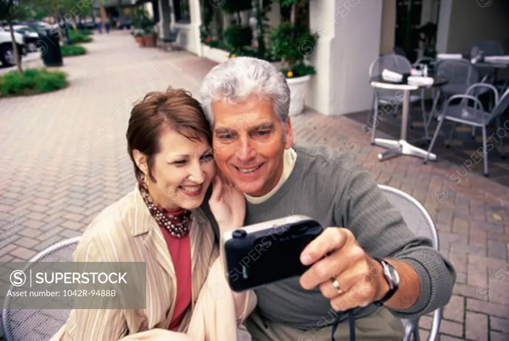 Mid adult couple taking a photograph of themselves