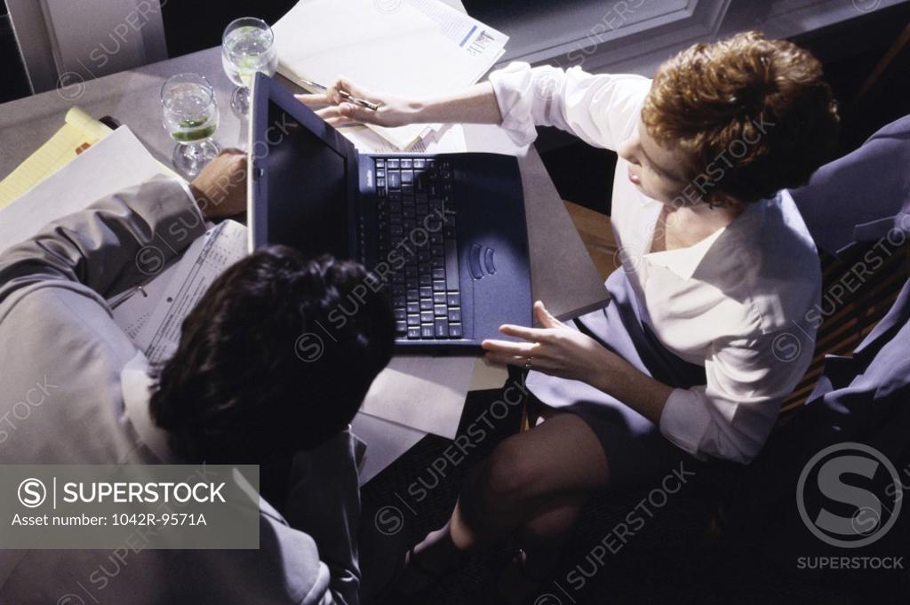 Stock Photo: 1042R-9571A High angle view of a businessman and a businesswoman working on a laptop