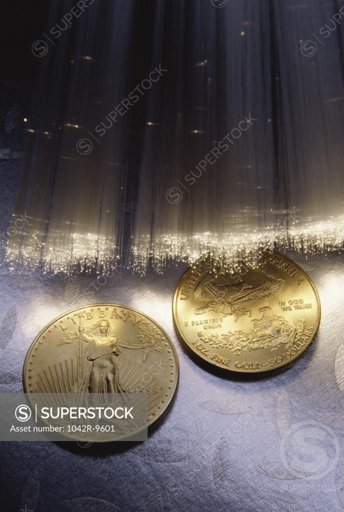 Stock Photo: 1042R-9601 Fiber optics near two gold coins