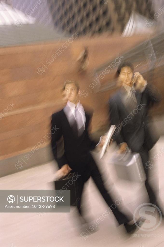 Stock Photo: 1042R-9698 Two businessmen walking holding briefcases