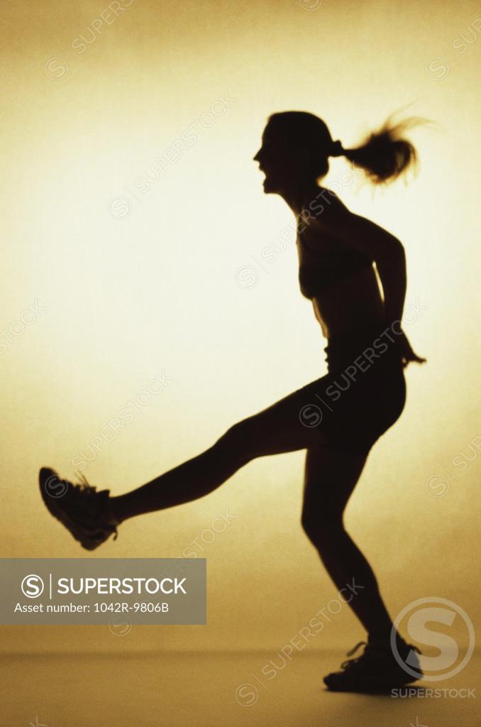 Stock Photo: 1042R-9806B Silhouette of a young woman exercising