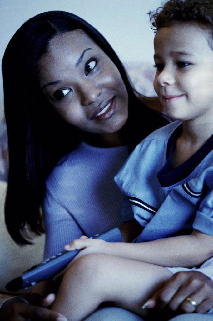 Close-up of a young woman watching television with her son