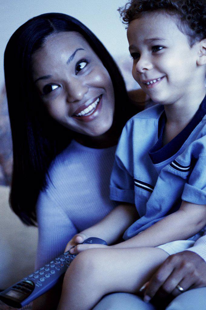 Close-up of a young woman watching television with her son