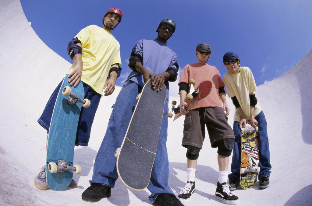 Low angle view of a group of young men holding skateboards