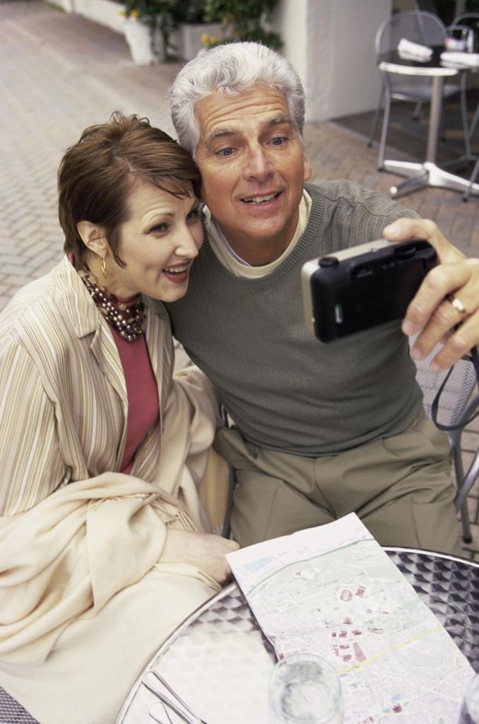 Mid adult couple taking a photograph of themselves