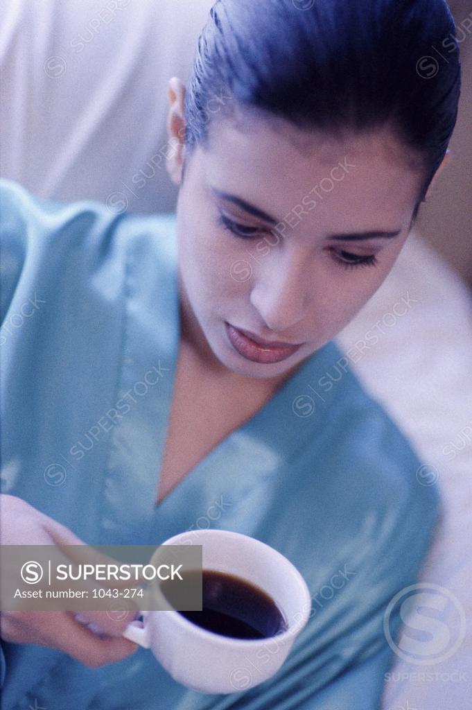 Stock Photo: 1043-274 Young woman holding a cup of coffee