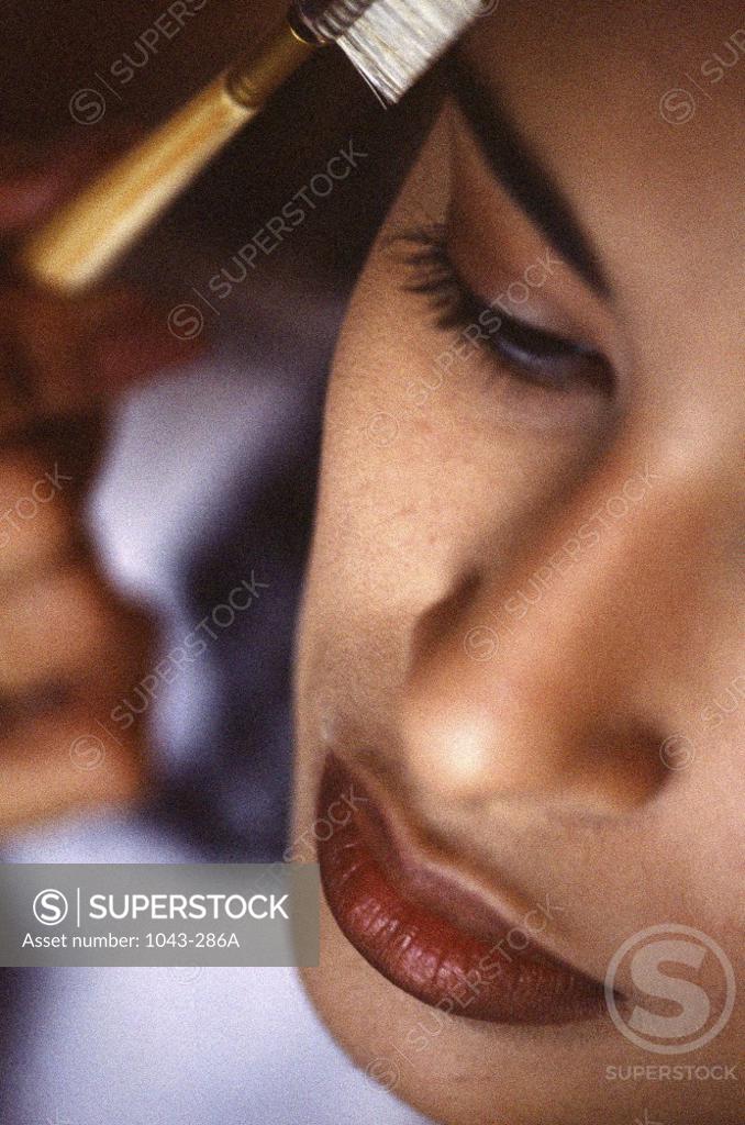 Stock Photo: 1043-286A Close-up of a young woman combing her eyebrows
