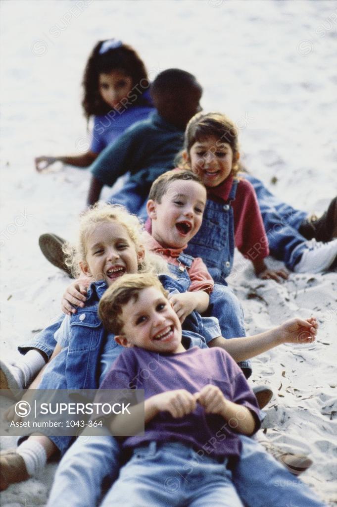 Stock Photo: 1043-364 Group of children lying on the sand