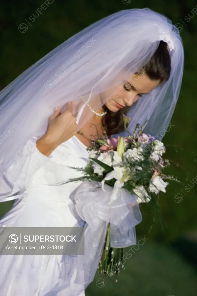 Side profile of a bride holding a bouquet of flowers