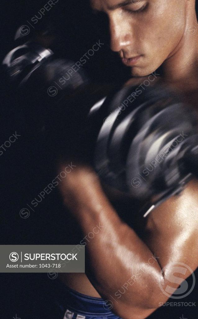Stock Photo: 1043-718 Young man exercising with dumbbells