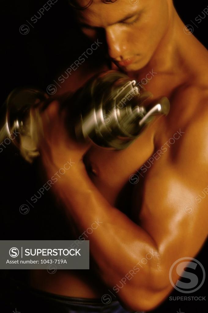 Stock Photo: 1043-719A Young man exercising with dumbbells