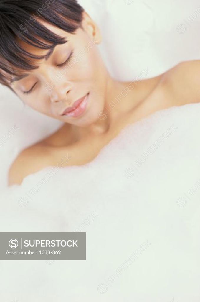 Stock Photo: 1043-869 Young woman lying in a bubble bath with her eyes closed
