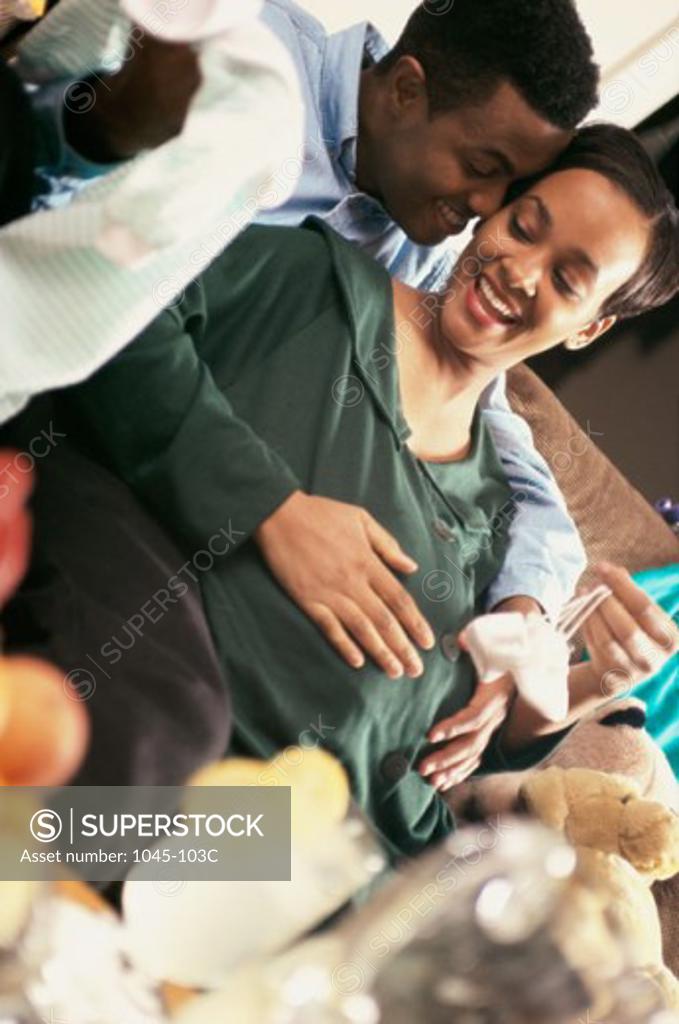 Stock Photo: 1045-103C Young man touching his pregnant wife's abdomen
